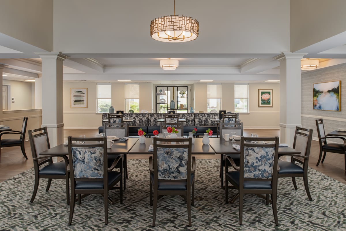 Dining room at The Meadows with set tables and pendant lighting